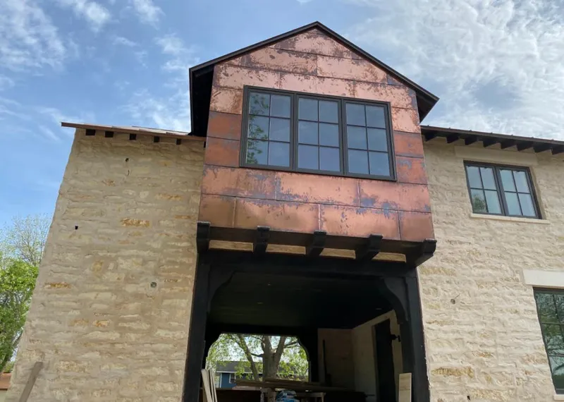 Copper metal panel facade on a stone building for Metal Roof Coating in Magnolia