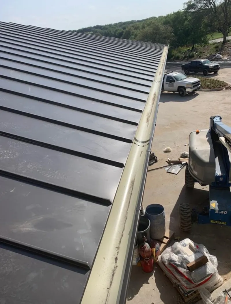 Standing seam panel and gutter detail on a metal roofing jobsite in Magnolia